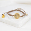 Gold bracelet with a star-shaped clasp on a white surface