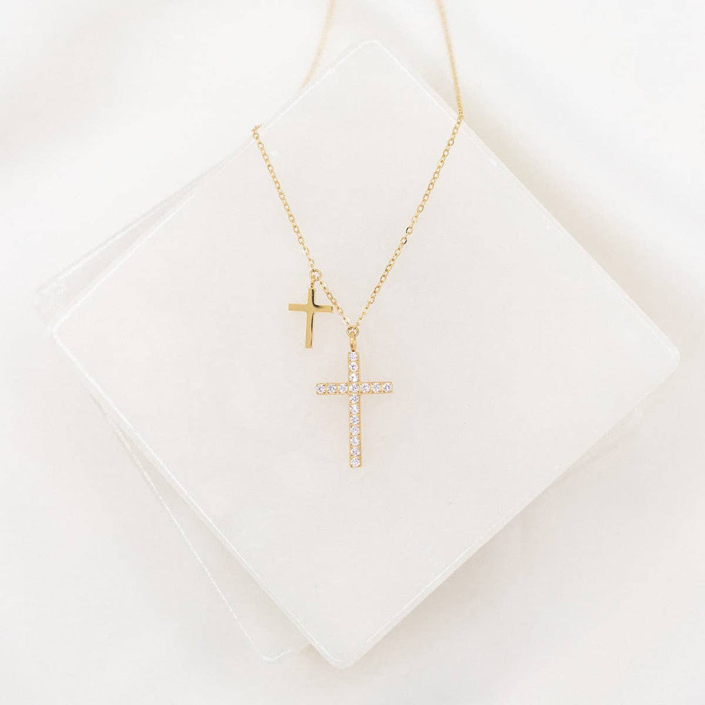 Gold cross necklace on a white background