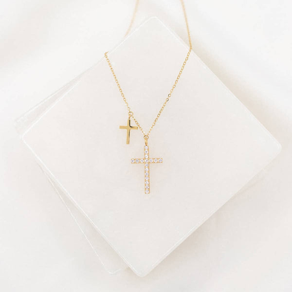 Gold cross necklace on a white background