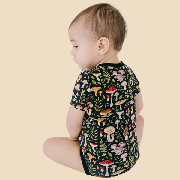 Baby wearing a romper with mushroom pattern 