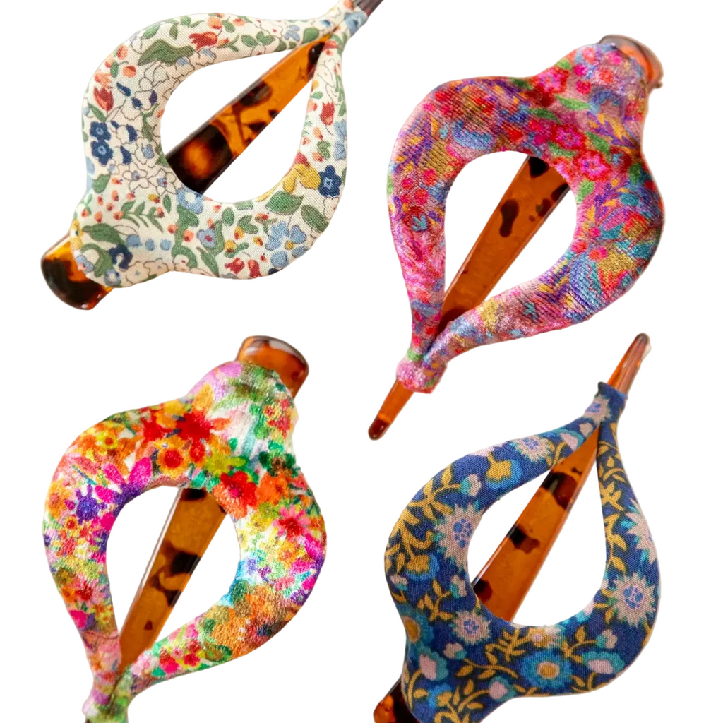 Four colorful floral-patterned hair clips on a white background