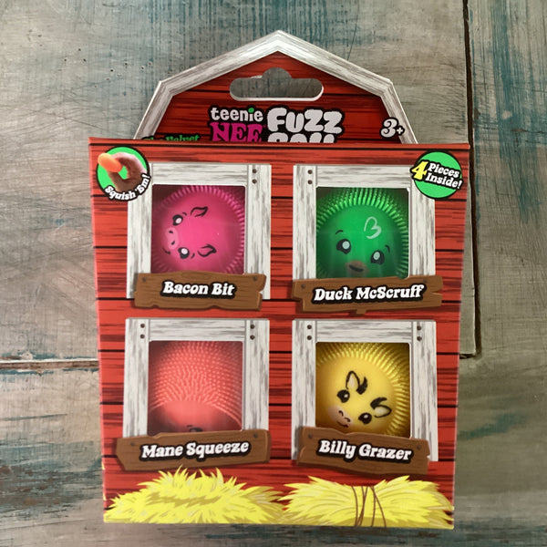 Teenie Fuzz Nee Doh plush toy packaging featuring four character bunnies: Bacon Bit, Duck McScruff, Mane Squeeze, and Billy Grazer, displayed on a rustic wooden background.