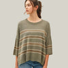 Woman wearing a green striped sweater against a plain background