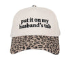 Cap with leopard print brim and text 'put it on my husband's tab' on a white background