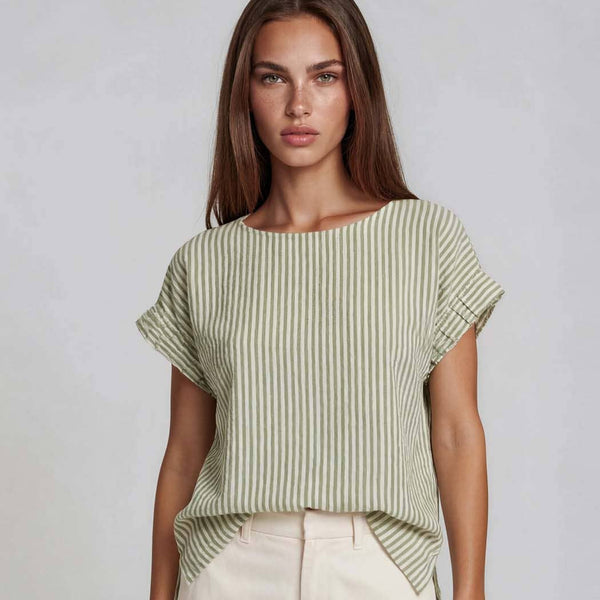 Woman wearing a green and white striped top with ruffled sleeves on a plain background