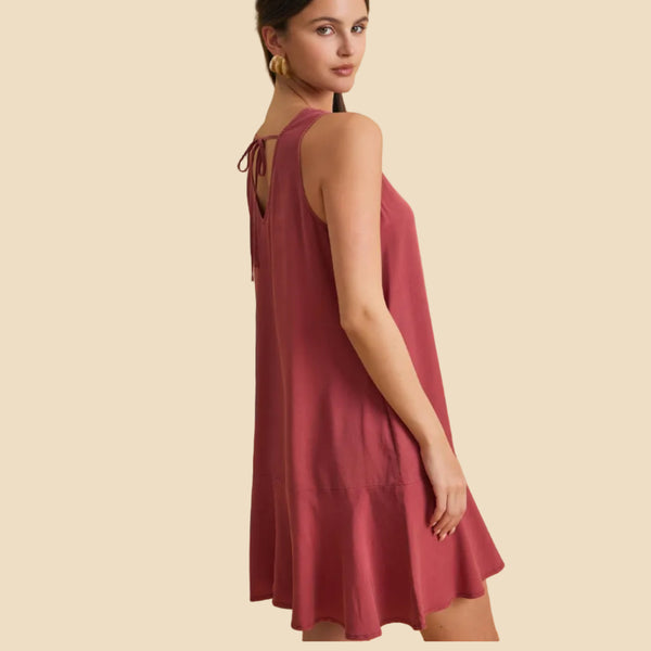 Woman wearing a pink dress against a beige background