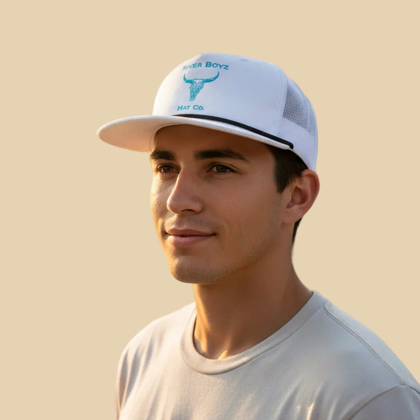 Man wearing a white cap with branding on a beige background