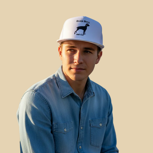 Person wearing a white cap with a logo and blue shirt against a beige background