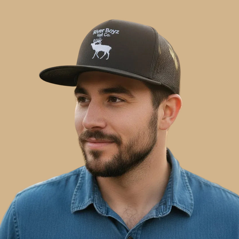 Man wearing a black cap with 'River Boyz Hat Co.' logo on a beige background
