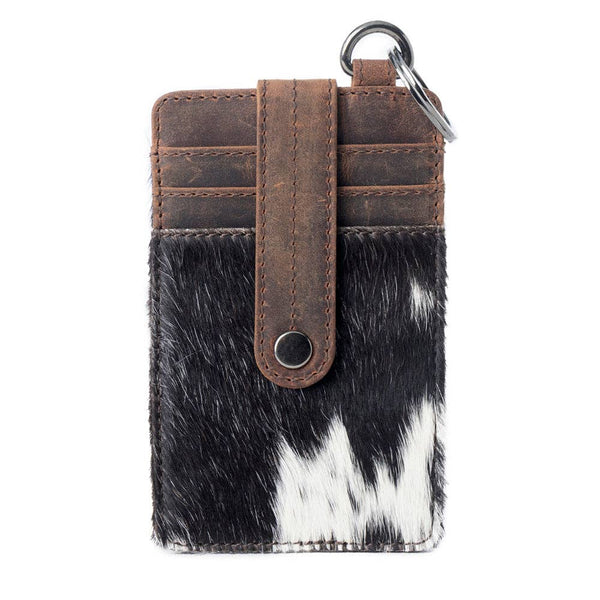 Phone case with cowhide design and brown leather strap on a white background