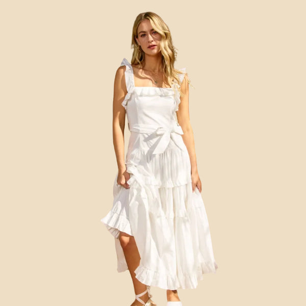 Woman in a tiered white dress on a neutral background