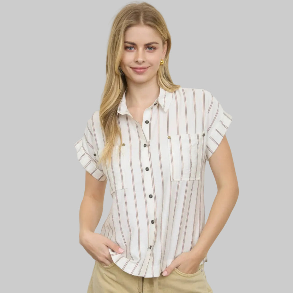 Woman wearing a striped shirt and beige pants against a white background