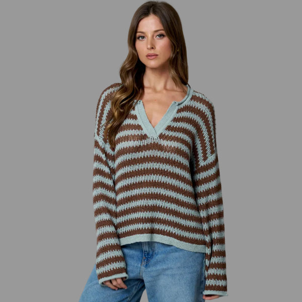Woman wearing a striped sweater and jeans against a plain background