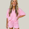 Woman wearing a pink outfit with scalloped hem
