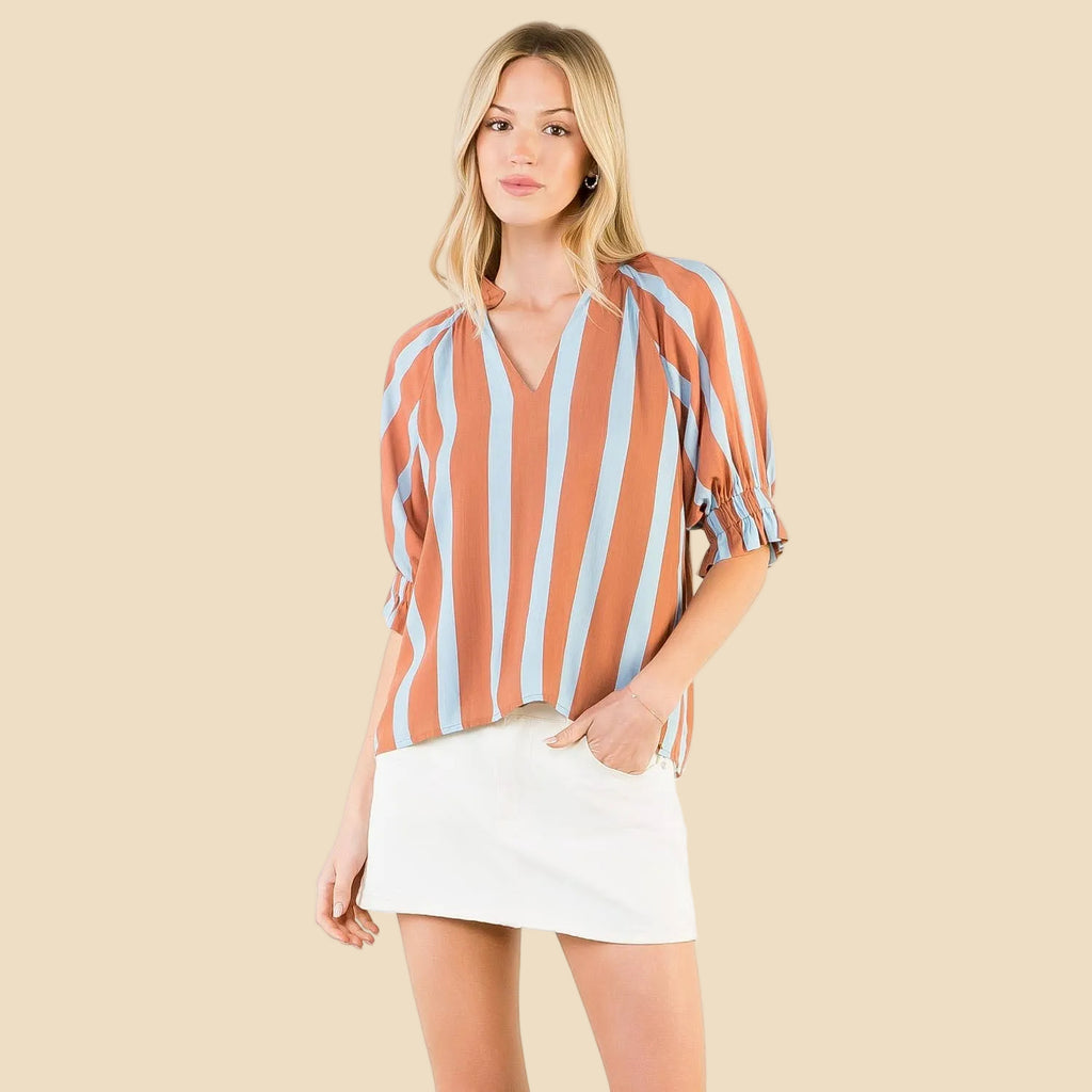 Woman wearing a striped blouse and white skirt on a white background