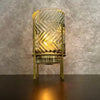 Decorative lamp with zigzag pattern on a textured wall background