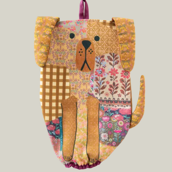 Dog-shaped backpack with floral and checkered patterns on a grey background