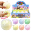 Crispy Squeezable Balls with packaging and a hand holding one of the balls.
