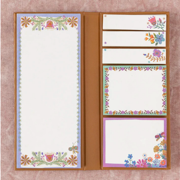 Floral design notepad with tear-off pages on a textured brown background