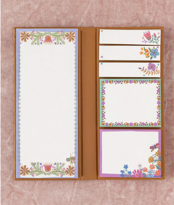 Floral design notepad with tear-off pages on a textured brown background