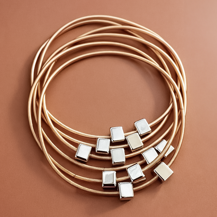 Set of gold necklaces with square pendants on a brown background