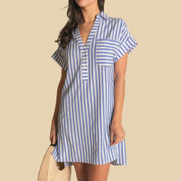 Woman wearing a blue and white striped dress against a neutral background