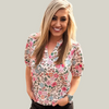 Woman wearing a floral blouse standing in an open field