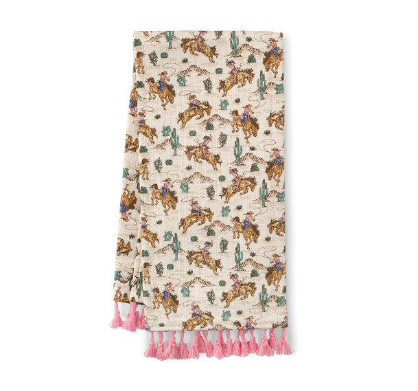 Blanket with cowboy and horse pattern and pink tassels on a white background