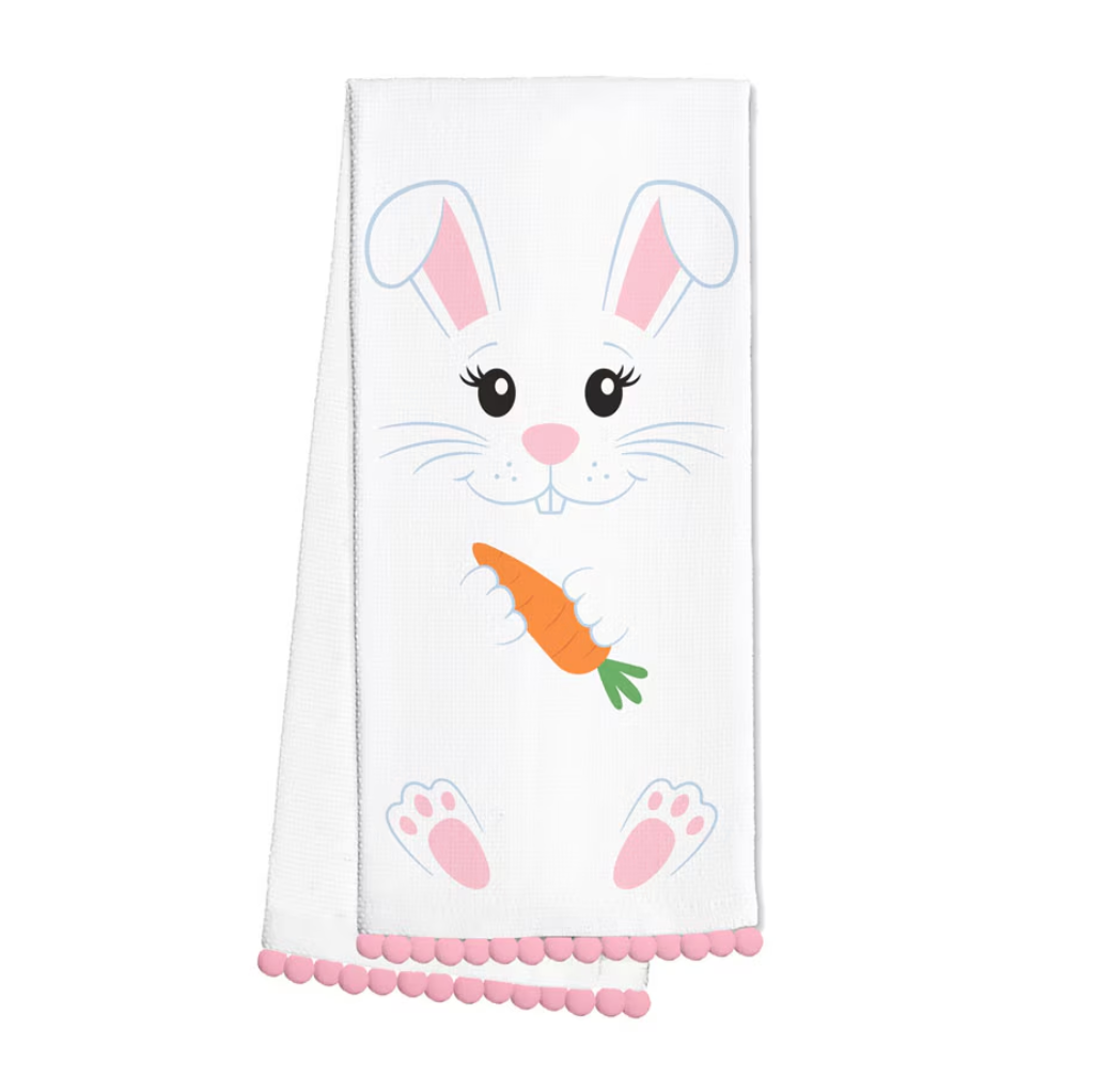 White towel with a bunny design, carrot, and pink trim on a white background