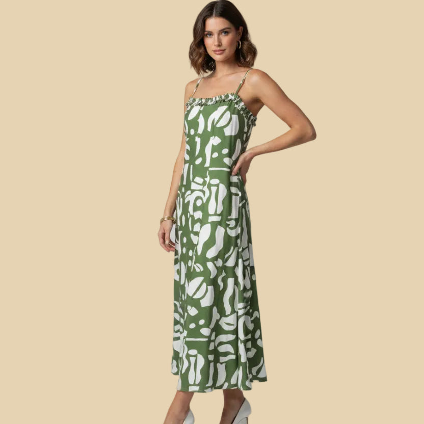 Woman wearing a green and white patterned dress on a beige background