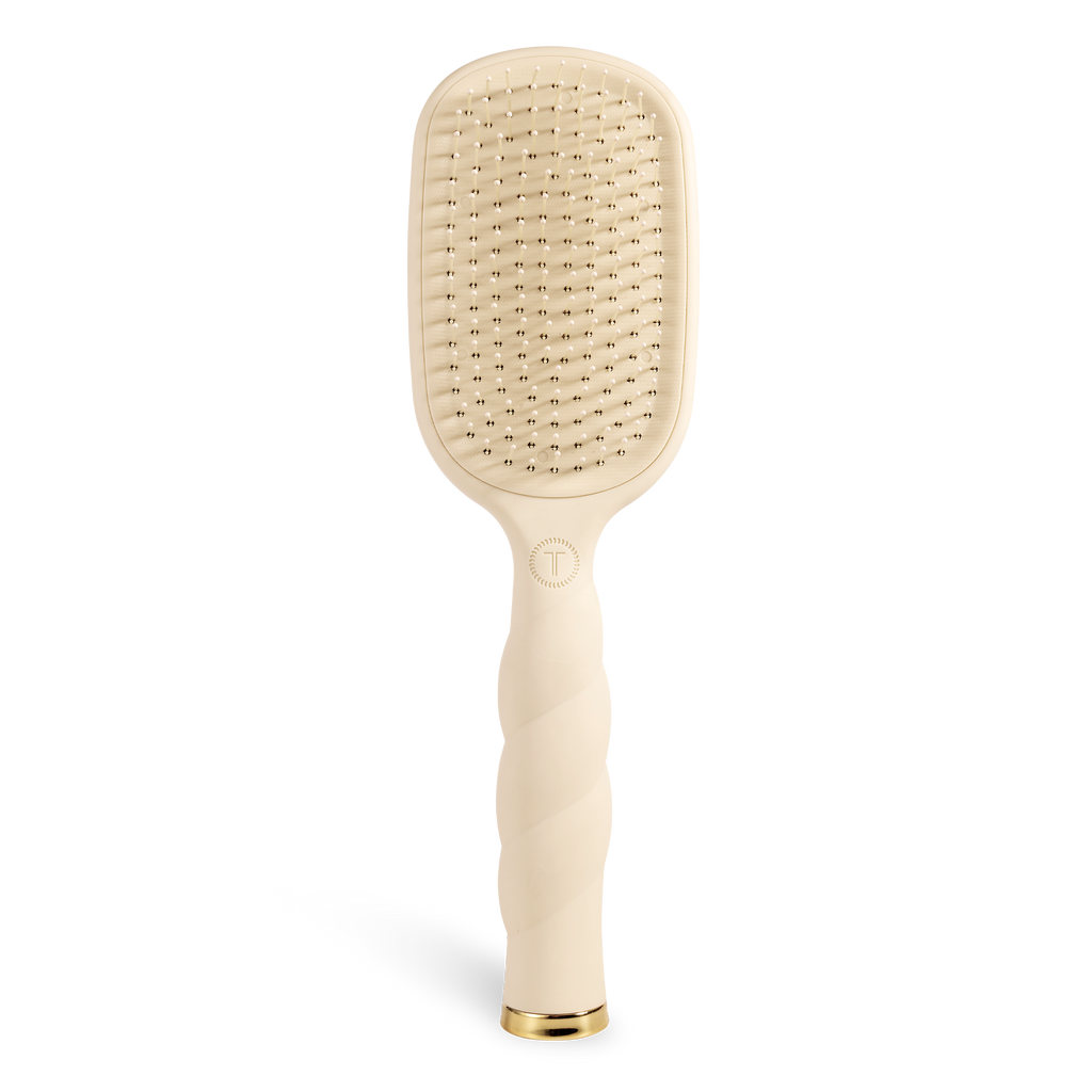 Beige paddle hair brush on a white background