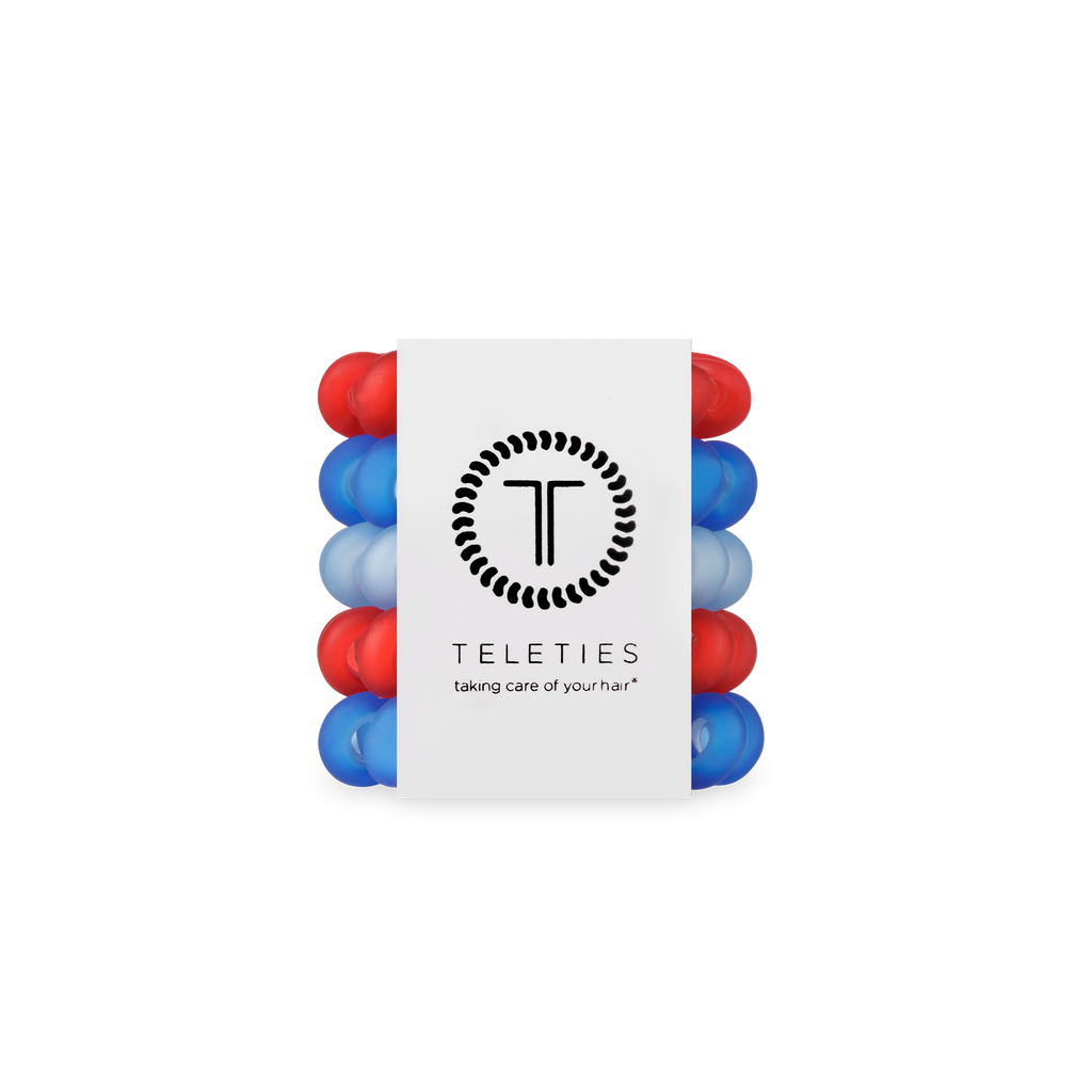 Stack of red and blue hair ties with a white label displaying 'Teleties' on a white background.