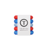 Stack of red and blue hair ties with a white label displaying 'Teleties' on a white background.
