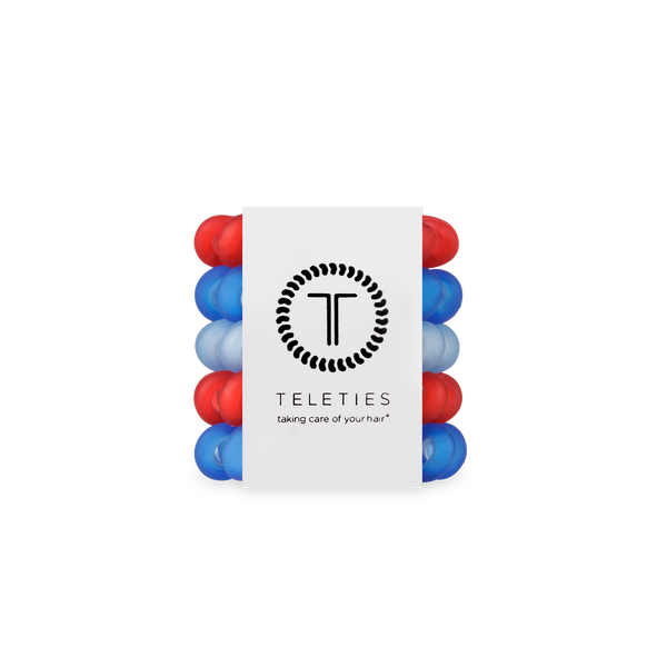 Stack of red and blue hair ties with a white label displaying 'Teleties' on a white background.