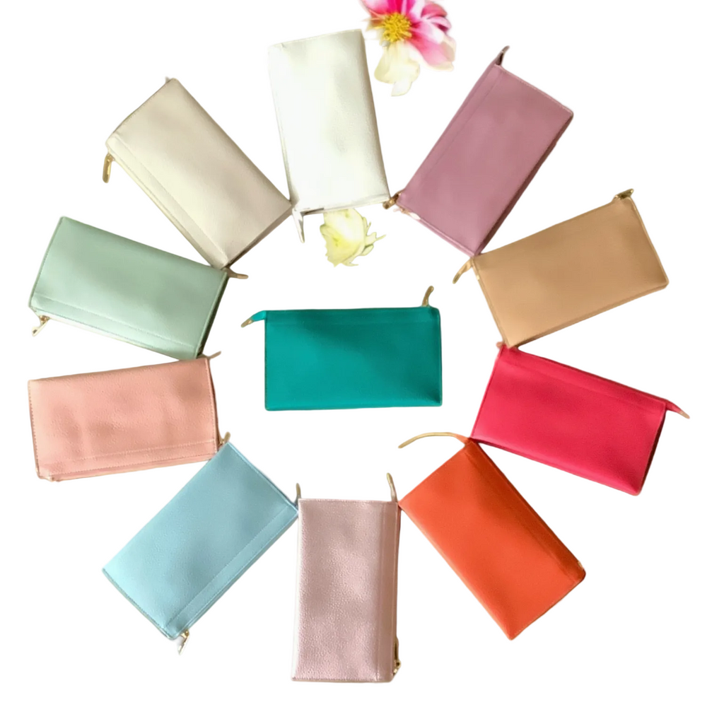 Colorful pouches arranged in a circular pattern on a green surface with flowers.