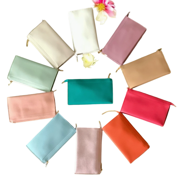Colorful pouches arranged in a circular pattern on a green surface with flowers.
