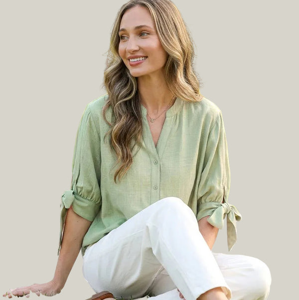 Woman in a sage green shirt with bow sleeves