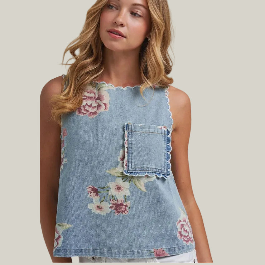 Woman wearing a denim top with floral patterns on a plain background