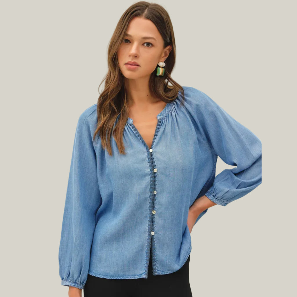 Woman wearing a blue denim blouse against a white background