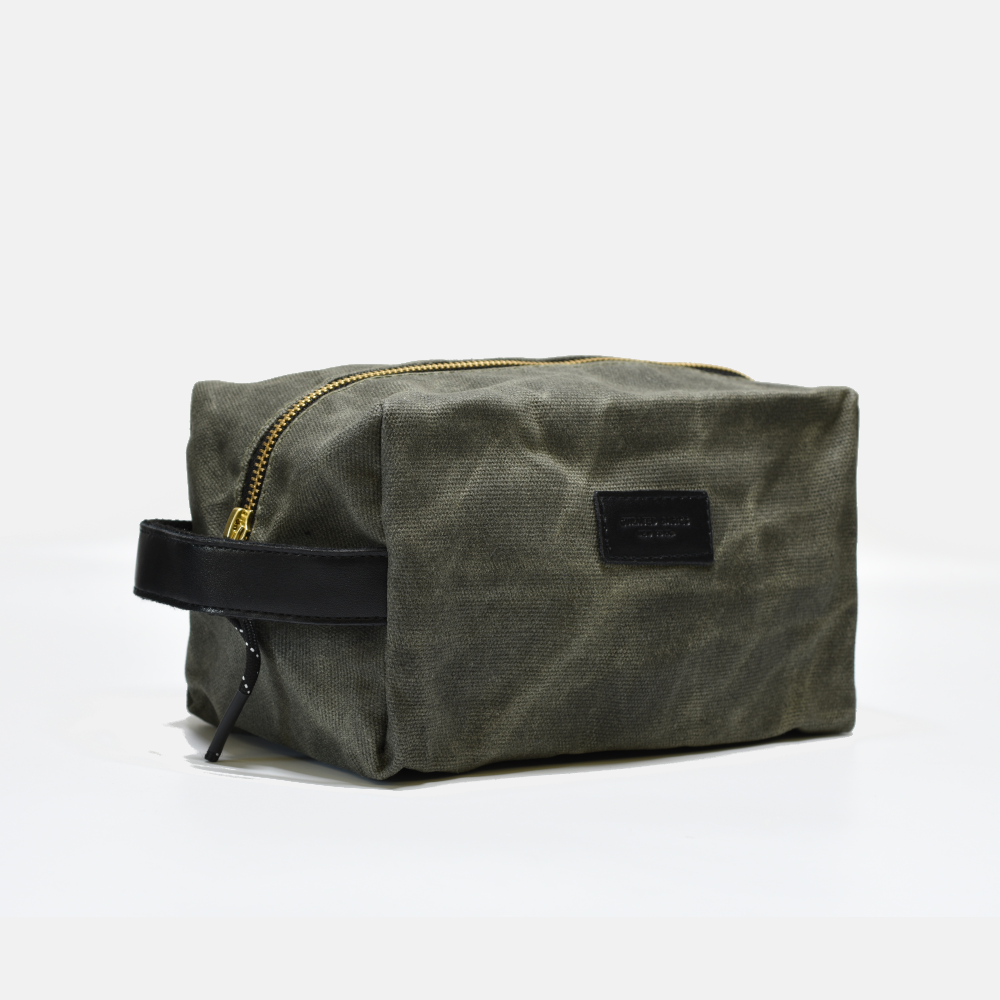 Waxed canvas toiletry bag with black zipper on a white background