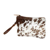 Brown and white cowhide clutch bag on a white background
