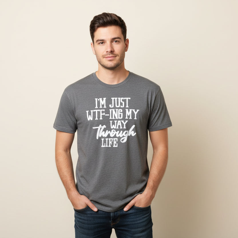 Gray t-shirt with humorous text on a hanger against a wooden wall.