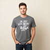 Gray t-shirt with humorous text on a hanger against a wooden wall.