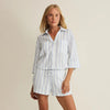 Woman wearing a striped shirt and shorts set on a beige background