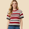 Woman wearing a red and white striped shirt with blue jeans on a beige background
