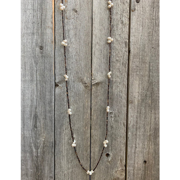 Necklace with white beads on a wooden background