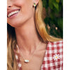 woman in red checked top wearring gold earring