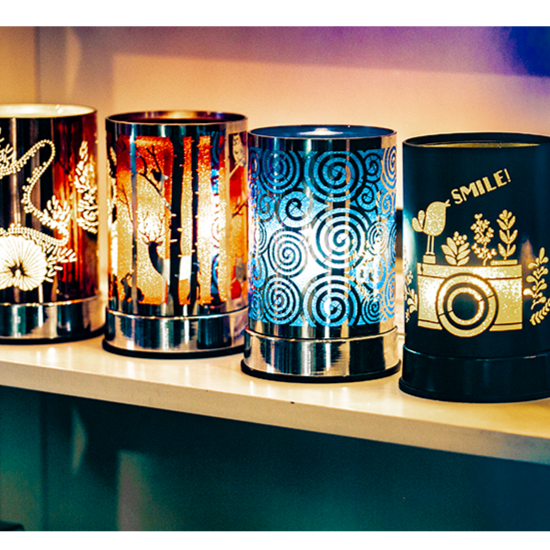 A collection of Scentchips warmers displayed on a shelf, featuring various designs and colors.